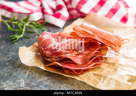 Scheiben Prosciutto Crudo auf Papier. Stockfoto