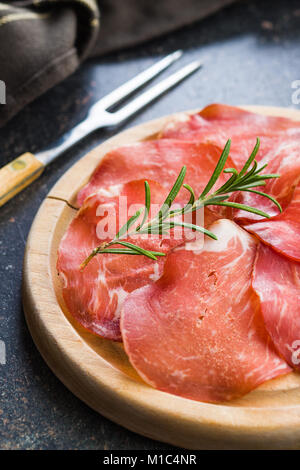 Scheiben Prosciutto Crudo auf Schneidebrett. Stockfoto