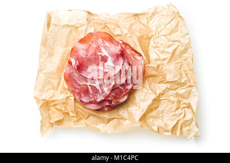 Scheiben Prosciutto Crudo auf Papier auf weißem Hintergrund. Stockfoto