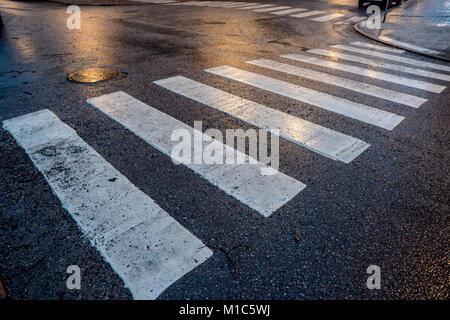 Lichter Reflexionen über den nassen Asphalt mit weißen Fußgängerübergänge Stockfoto