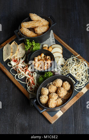 Große Auswahl an Snacks für Bier mit verschiedenen Soßen auf Pergament, Ansicht von oben Stockfoto