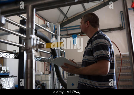 Männliche Arbeiter Überwachung ein Manometer von Speicher Stockfoto