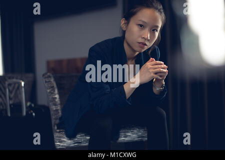 Schöne Frau im Hotel Zimmer sitzen Stockfoto