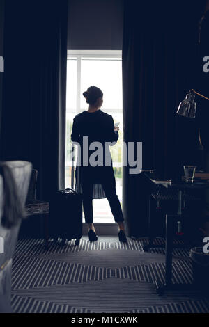 Frau mit Handy im Hotel Zimmer Stockfoto