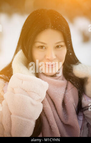 Porträt einer wunderschönen asiatischen Frau vor dem Hintergrund der Snow Park. Stockfoto