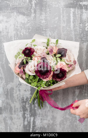 Schönen luxus Blumenstrauß aus gemischten Blumen in der Frau die Hand. Die Arbeit des Floristen zu einem Blumenladen Stockfoto