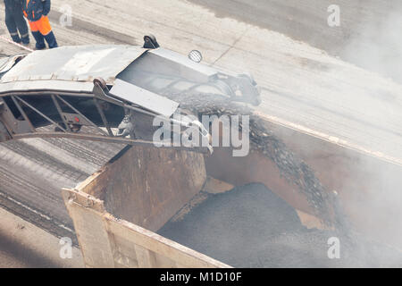 Straßenarbeiten. Asphalt entfernen Maschine laden in Pulverform Asphalt auf dem LKW Stockfoto