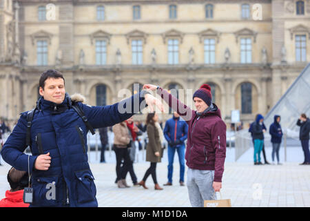 Die Menschen nehmen selfies und Fotos an der Glaspyramide Eingang des Louvre in Paris, Frankreich Stockfoto