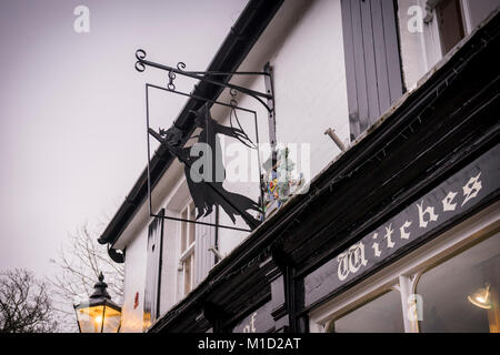 'Coven neuer Hexen' alter Shop mit schrulligen Schild in der Form eines fliegenden Hexe in Burley an einem regnerischen Tag in der New Forest, Hampshire, England, Großbritannien Stockfoto