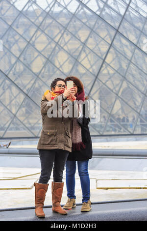 Die Menschen nehmen selfies und Fotos an der Glaspyramide Eingang des Louvre in Paris, Frankreich Stockfoto