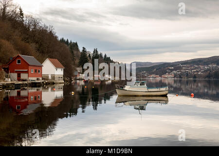 Forresfjorden, Karmoy in Norwegen - Januar 10, 2018: Ein kleines Motorboot im Wasser ruhen im Fjord Forresfjorden. Boot Häuser am Meer. Schönen Himmel und blaues Licht Stockfoto