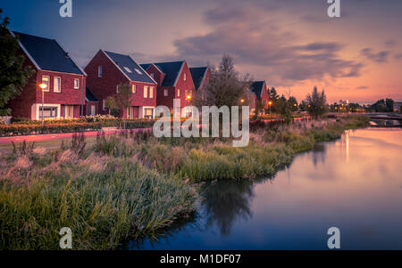 Lange Belichtung Night Shot der Straße mit modernen ökologischen Mittelklasse Familie Häuser mit umweltfreundlichen River Bank in Veenendaal, Niederlande. Einlesen der VIN Stockfoto