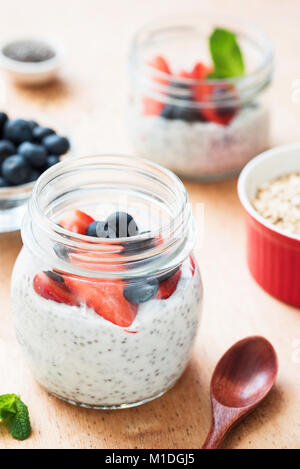 Chia Milchreis mit frischen Beeren im Glas. Gesundes Frühstück, Diäten, Reinigung, gesunden Lebensstil Konzept. Selektiver Fokus, weichen Morgenlicht. Stockfoto