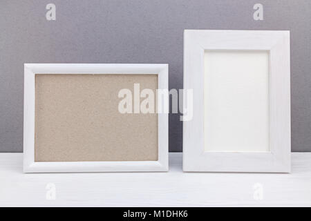 Horizontale und vertikale weiße Holz- leeren Fotorahmen auf grauem Hintergrund Stockfoto