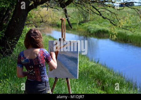 Weibliche Landschaft Künstler malt einen schönen kleinen Fluss Szene auf Leinwand. Stockfoto