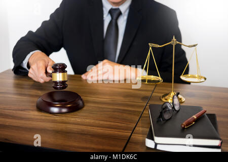 Männlichen Richter Rechtsanwalt In A Gerichtssaal auffällig The Hammer auf klingenden Block. Stockfoto