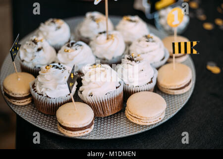 Süße leckere Cupcakes Dessert und Macarons In Schokoriegel auf Tisch. Leckeres süßes Buffet. Hochzeitsdekorationen Stockfoto