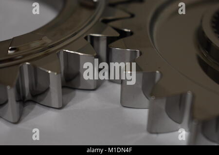 Zwei sehr glänzend motor sport Zahnräder mit Ihre Zähne im Eingriff auf einem weißen Hintergrund. Stockfoto