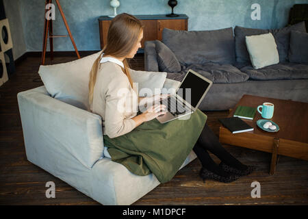 Nette Frau mit Laptop zu Hause Büro Stockfoto