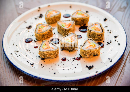 Schließen Sie köstliche Dreieck sushi Rollen auf Platte Stockfoto