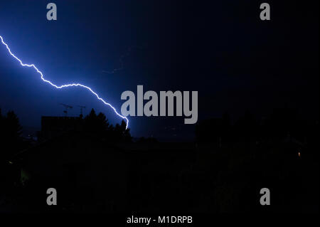Blitz bei Nacht leuchtet der Himmel über die Häuser im Sommer Sturm Stockfoto