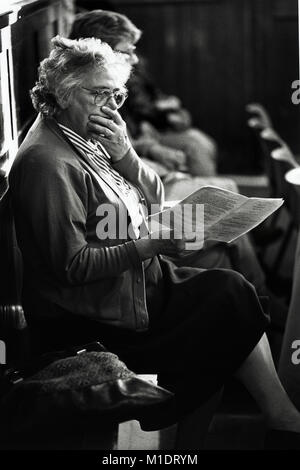 Alte Dame im Publikum lesen das Programm bei kleinen Eisteddfod in Village Hall an Trefeglwys Powys Wales UK Stockfoto