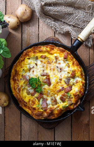 Hausgemachte Frühstück mit leckeren Omelette mit Schinken, Kartoffeln und Käse eingereicht, Ansicht von oben Stockfoto