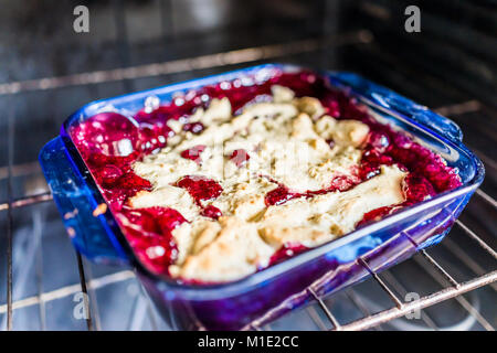 Nahaufnahme des Hot Red Cherry cobbler in Glas Backform Teller drinnen am Ofen Rack mit Blasen, goldene Kruste Stockfoto