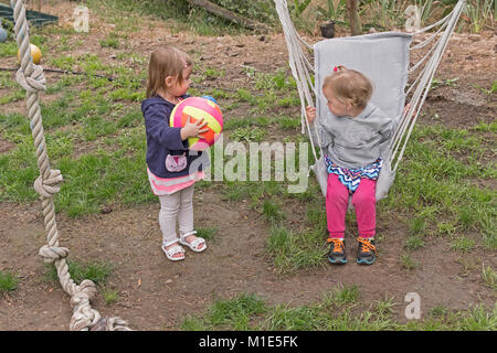 Cousins Spielen im Hof an einem Sommertag Stockfoto