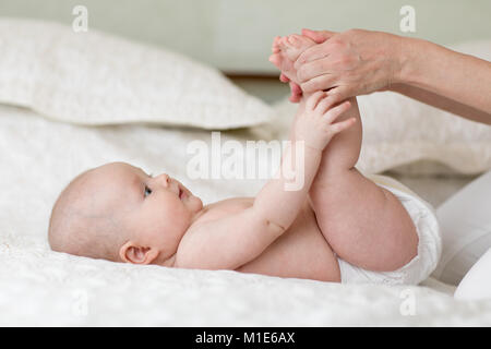 Mutter oder masseuer massieren Baby Mädchen im Zimmer Stockfoto