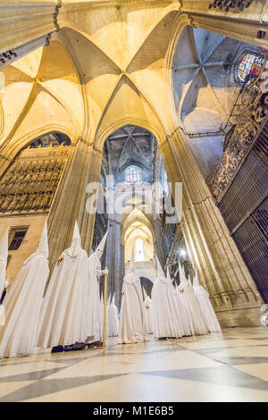 Büßer der Bruderschaft des 'La Paz' in der Ausbildung in der Kathedrale von Sevilla. Stockfoto