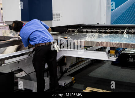 Mechaniker Arbeiter Reparatur CNC-Laserschneidanlage Stockfoto