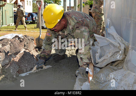 Sgt. Jose Garcia, eine Tischlerei und Mauerwerk Spezialist für die 561St Ingenieur Gesellschaft zugeordnet, 84th Engineer Battalion, 130 Engineer Brigade, 8 Theater Sustainment Command, glatte, Zement bei Schofield Baracke, Hawaii, am Jan. 26, 2018. Garcia ist ein Teil der Konstruktion team Festlegung der Bürgersteig und Grundlage für die 25 Infanterie Division 3. Brigade Combat Team Bronco Memorial in der Nähe platziert werden. (U.S. Armee Stockfoto