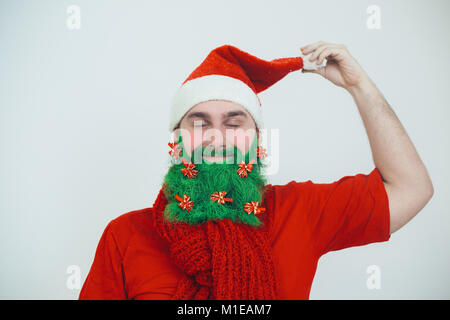 Santa Clause in roter Kleidung mit grünem Bart mit roten Bogen wie ein Weihnachtsbaum dekoriert Stockfoto