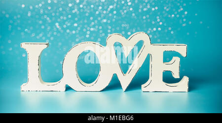 Weiß Wort LIEBE auf türkis-blauen Hintergrund mit Bokeh, Vorderansicht. Modernes Layout oder Mock up für Karte oder Grußansage Stockfoto