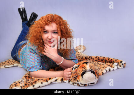 Porträt der Schönen redhead liegen im Studio auf der Leopard skin Stockfoto