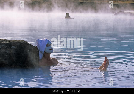 Island. Myvatn. Myvatn Nature Baths. Frau tragen Schönheit Maske, ein Handtuch auf dem Kopf, sitzen in geothermischen Spa. Stockfoto