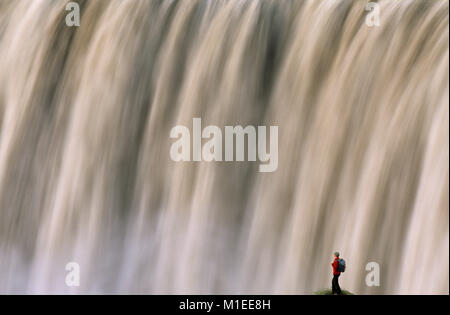 Island. Myvatn. Wasserfall Dettifoss. Touristische, Frau, die an der Klippe am Wasserfall. Stockfoto