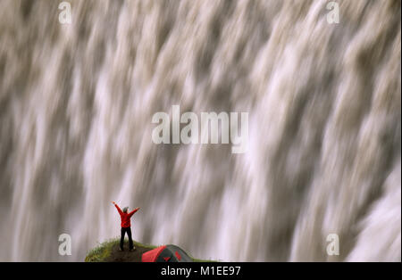 Island. Myvatn. Wasserfall Dettifoss. Touristen, stehende Frau von Zelt am Wasserfall. Stockfoto