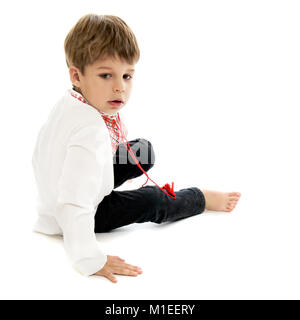 Little Boy in der Ukrainischen bestickt Shirt sitzen auf weißem Hintergrund Stockfoto