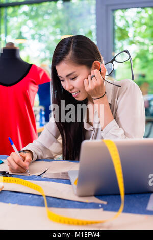 Asiatische Modedesigner der Ausarbeitung von Entwürfen für Aussparungen Stockfoto