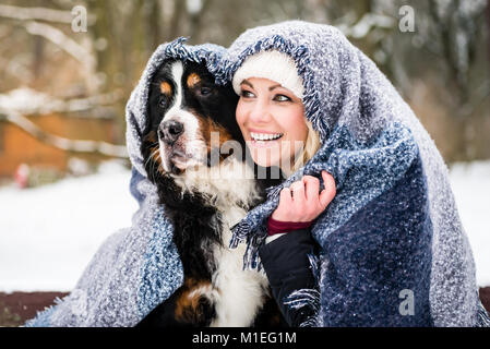 Frau und ihr Hund warm an kalten Winter Tag unter einer Blanke Stockfoto