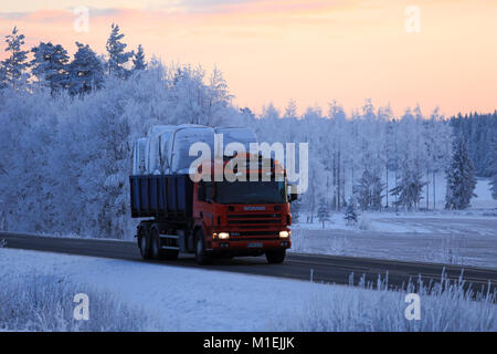 SALO, FINNLAND - Januar 21, 2018: Rote Scania 124G Kipper von Wallway Transporte Silageballen entlang der Autobahn im Winter bei Sonnenuntergang. Stockfoto