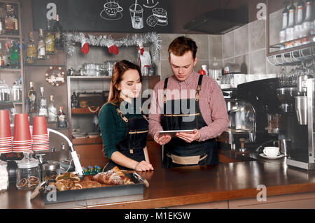 Paar Barista im Cafe. Schöner Mann und attraktive Frau macht Kaffee. Lebensmittel- und Getränkeindustrie Konzept Stockfoto