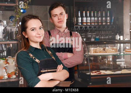 Paar barista Seite an Seite im Cafe. Schöner Mann und attraktive Frau macht Kaffee. Lebensmittel- und Getränkeindustrie Konzept Stockfoto