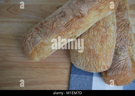 Rustikales Essen mit hausgemachten artisan Ciabatta weißes Brot auf einem natürlichen Holz Schneidebrett mit obenliegender Ansicht. Stockfoto
