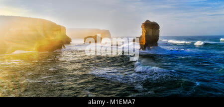 Mächtige Kampf zwischen Meer, Land und Licht bei Sonnenaufgang um zwölf Apostel Felsformation im Marina Park an der Great Ocean Drive, Australien. Stockfoto