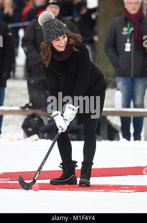 Die Herzogin von Cambridge hits a hockey Kugel als sie und der Herzog von Cambridge eine Gruppe lokaler bandy Hockey Spieler an Vasaparken in Stockholm am ersten Tag Ihres Besuches in Schweden treffen. Stockfoto