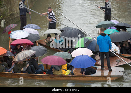 Touristen unter den Sonnenschirmen, während Sie stochern auf dem Fluss Cam in Cambridge, wie die sintflutartigen Regenfälle und starke Winde angekommen, wenn Sturm Georgina der Region getroffen. Stockfoto