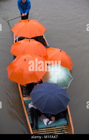 Touristen unter den Sonnenschirmen, während Sie stochern auf dem Fluss Cam in Cambridge, wie die sintflutartigen Regenfälle und starke Winde angekommen, wenn Sturm Georgina der Region getroffen. Stockfoto